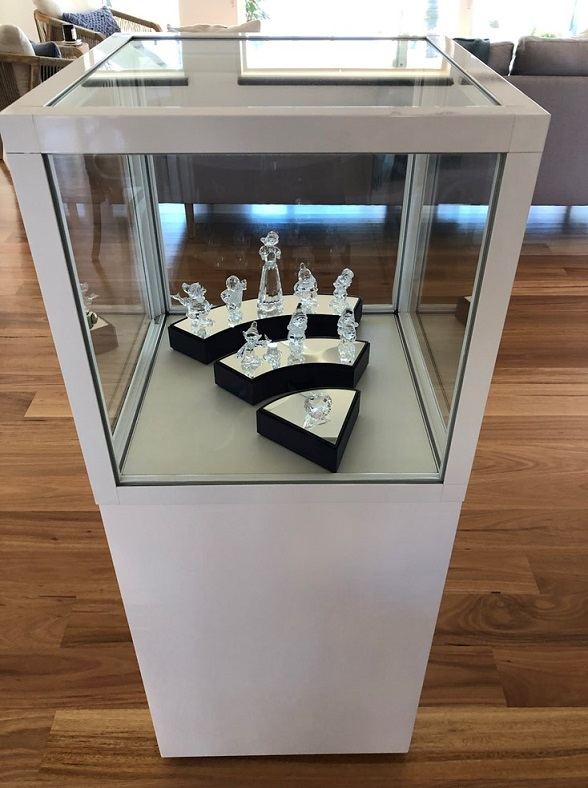 The custom, white CBDL pedestal cabinet from Showfront is ideal for displaying Swarovski crystals.