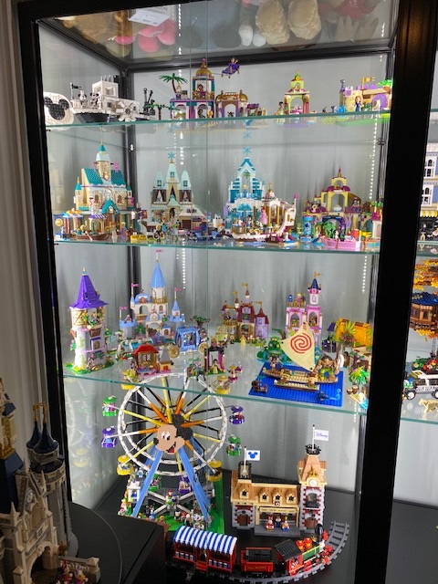 A Disney Lego collection and classic collectables in a Disney display cabinet from Showfront.