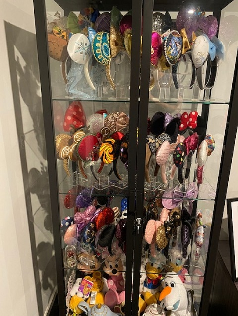 Mickey Mouse and Minnie Mouse ears collection and Disney plush toy collectables in a Disney display cabinet from Showfront. 
